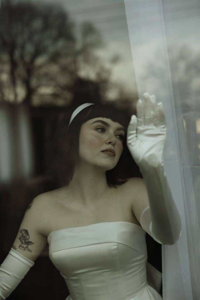 A bride looking out the window with a soft gaze