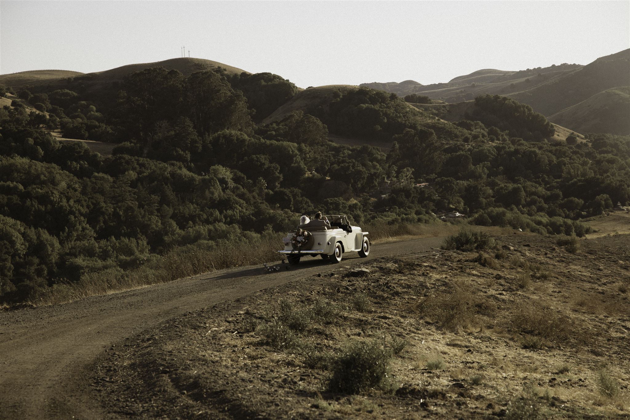 Vintage car driving away during sunset