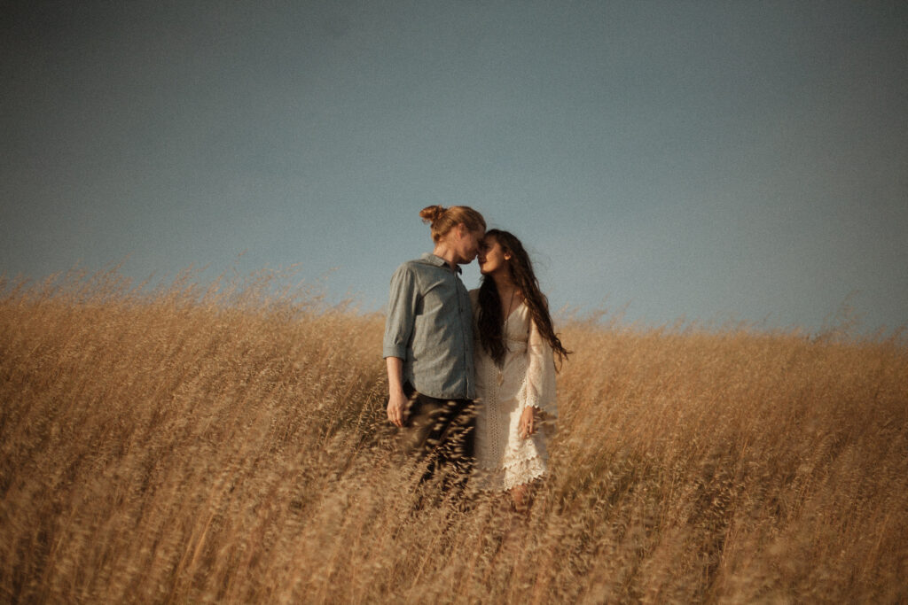 Engagement photography during golden hour in a large field